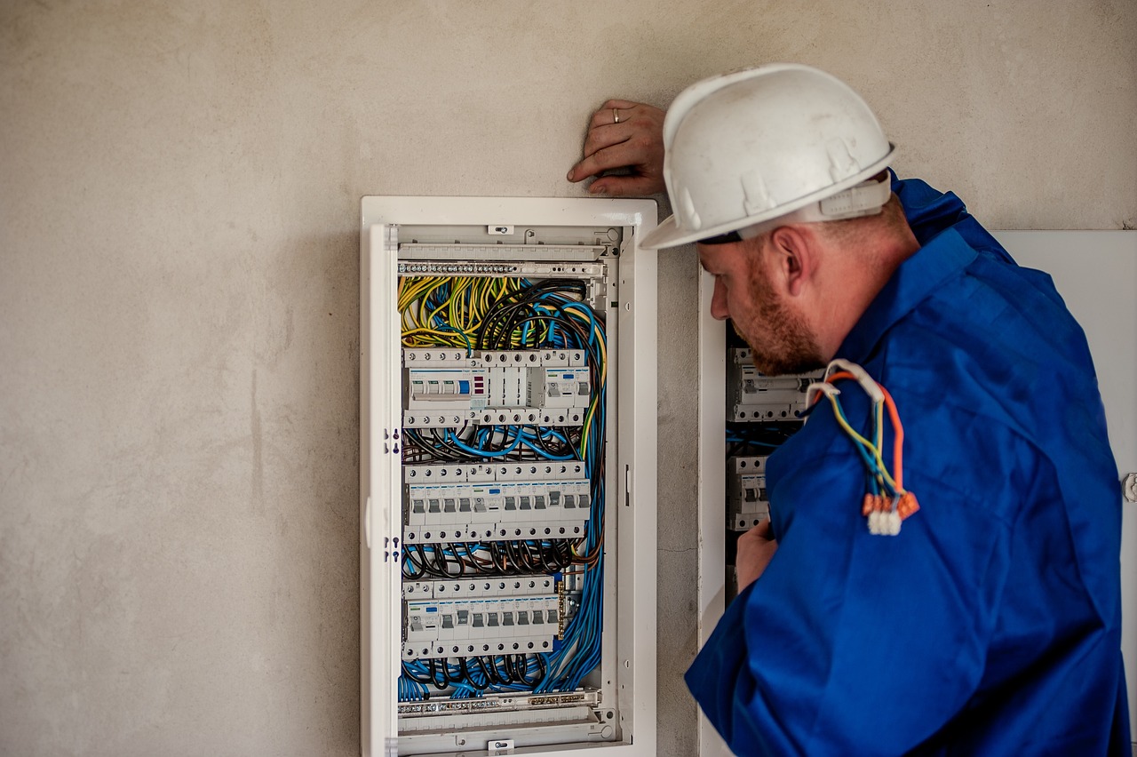 An experienced electrician inspecting a junction box to troubleshoot electrical faults and ensure proper wiring.